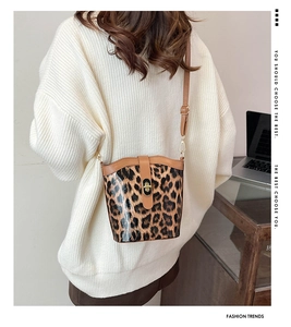 Chic leopard print bucket bag with metal lock shown on shoulder for daily commute