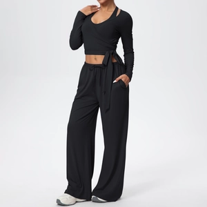 Détail du haut de yoga cache-cœur noir avec liens et pantalon large à taille haute