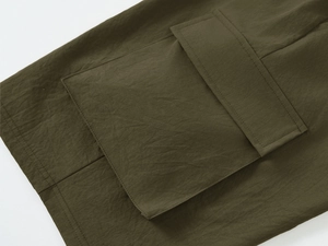 Detail shot of army green cargo shorts featuring durable fabric and flap pocket stitching