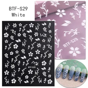 Macro detail of white cherry blossom nail decals with 3D texture and branch patterns