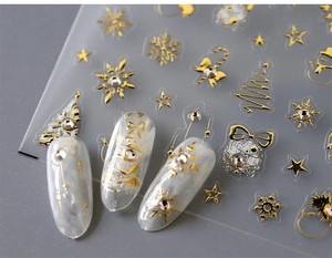Close-up of gold foil Christmas nail stickers with snowflakes and rhinestone accents