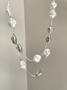 Detail of double-layer necklace with white baroque pearls and silver irregular metal beads