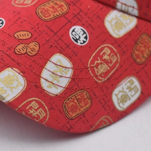 Détail macro de la visière de casquette rouge en coton avec symboles de chance brodés