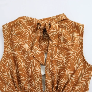 Brown backless vacation maxi dress featuring palm leaf print and elegant neck tie bow