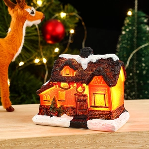 Close-up of glowing resin snow house with warm lights and festive Christmas decor