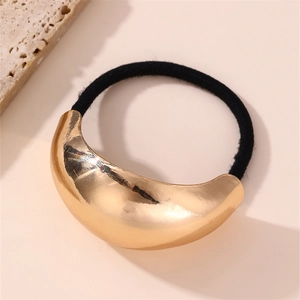 Detail of minimalist gold crescent metal hair tie with polished mirror finish and elastic cord