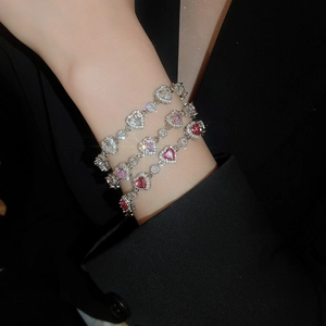Close-up of stacked heart-shaped zircon bracelets in white, pink, and burgundy stones