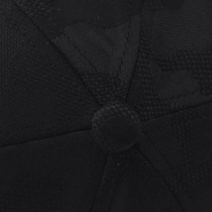 Macro detail of black baseball cap showing jacquard texture and premium stitching