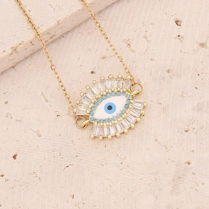 Macro shot of gold Evil Eye pendant with blue stone on minimalist stone background