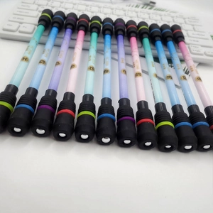Detailed close-up of 12 zodiac theme spinning pens arranged on a white keyboard background