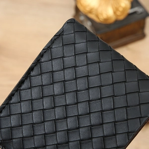 Macro shot of black woven leather texture and fine stitching on a men's wallet