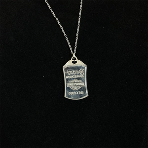 Detailed close-up of a silver rectangle pendant featuring engraved motorcycle brand logo