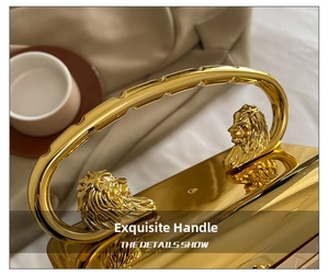 Detailed view of polished gold lion head handle on an acrylic luxury evening handbag