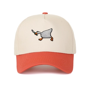 Detail showing high-quality embroidery of a goose with a knife on a bicolor baseball cap