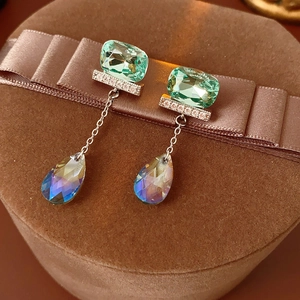 Dettaglio orecchini in argento con gemme verdi e nappe a goccia cangianti di lusso