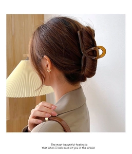 Gros plan d'une grande pince à cheveux en résine marron ambre dans un style élégant
