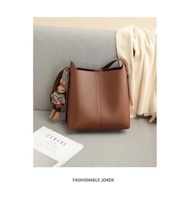 Dettaglio della borsa a secchiello in pelle marrone scuro con ciondolo a forma di coniglio
