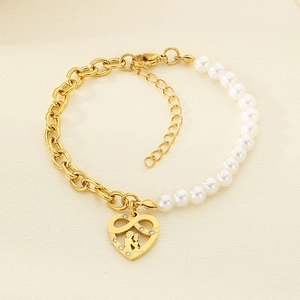 Detail of half pearl half gold titanium steel bracelet with a diamond heart pendant