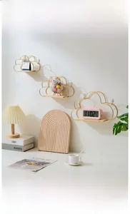 Three-piece gold metal cloud-shaped wall shelves with wooden base in a cozy setting