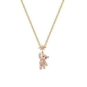 Gold bear pendant necklace with sparkling cubic zirconia and star detail on white background