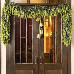 Realistic Norfolk pine Christmas wreath with four golden bells on vintage wooden door