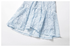 Close-up of light blue rose lace fabric with tiered ruffle layers and floral pattern