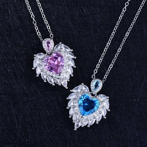 Detail of heart-shaped blue and pink crystal necklaces with angel wing stone settings