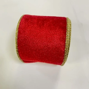 Detail view of red velvet Christmas ribbon with elegant gold metallic braided wired edges