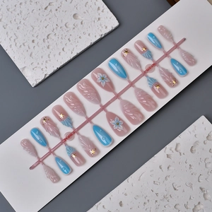 Close-up of 3D embossed flowers and starfish beads on pink and blue press-on nails