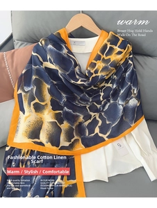 Detailed view of linen scarf showing giraffe pattern and orange contrast edges