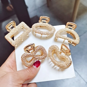 Set of five gold alloy hair claws with frosted glitter texture in varied geometric shapes