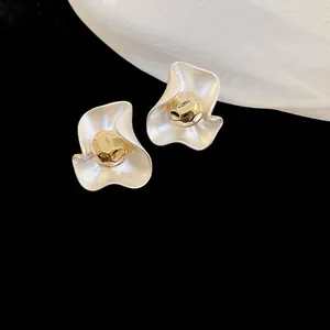 Elegant gold-plated flower stud earrings with pearl white petals on dark background