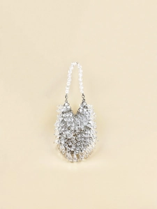 Close-up of transparent teardrop crystal beads and silver metal links on a luxury handbag
