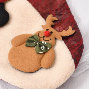 Macro detail of plush beige Christmas stocking featuring 3D felt reindeer with red nose