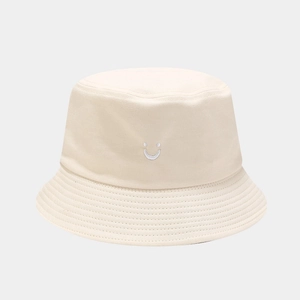 Detailed close-up of smile embroidery on beige cotton bucket hat with canvas texture
