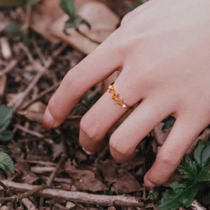Elegant gold ring featuring amber marquise gemstones and diamonds on a hand