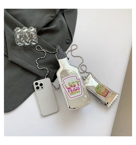 Detailed view of silver ketchup bottle shaped crossbody bag with metallic chain strap