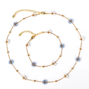 Titanium steel jewelry set featuring woven blue crystal and white pearl flower charms