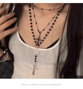 Detail of gothic layered black bead necklace with silver cross and ankh pendants