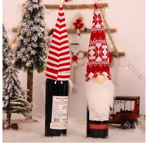 Close-up of knitted Christmas wine bottle covers with stripes, snowflakes and white beards