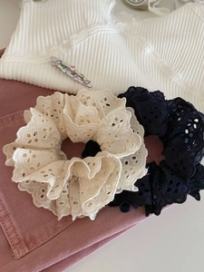 Vue détaillée de chouchous en dentelle et barrettes bijou sur tissus stylés