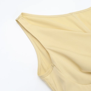 Détail de la robe en satin jaune montrant les coutures de qualité et la texture du tissu