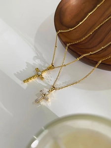 Close-up of gold-plated titanium cross necklaces with baguette and round-cut zircons