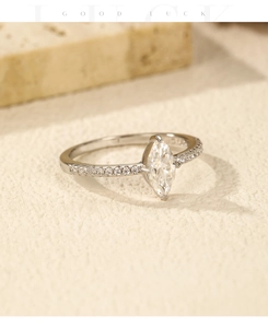 Macro detail of marquise cut moissanite ring with side accent diamonds on silver band