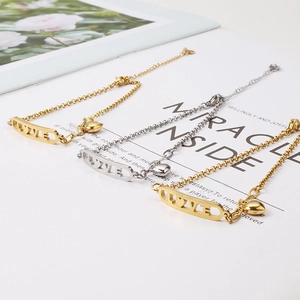 Détail de bracelets cœur en or et argent avec gravure LOVE sur fond blanc
