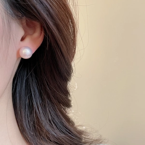 Close-up of a model wearing a premium lavender pearl stud earring with elegant luster