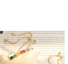 Detail of gold-plated adjustable bracelet featuring rainbow baguette-cut cubic zirconia