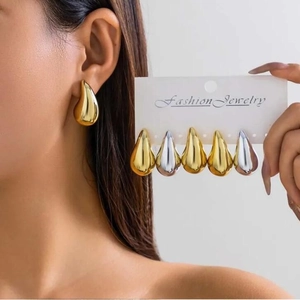 Elegant gold and silver teardrop earrings shown on model and display card