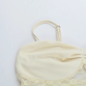 Gros plan sur une robe en dentelle crème avec bretelles et détails de broderie