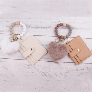 Detail of plush heart charm and silicone beaded wristlet keychain with card holder